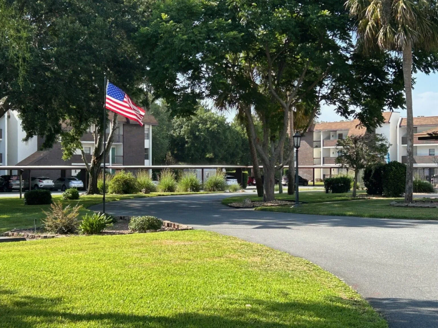 A view of buildings 2 and 3 with trees and American flag.