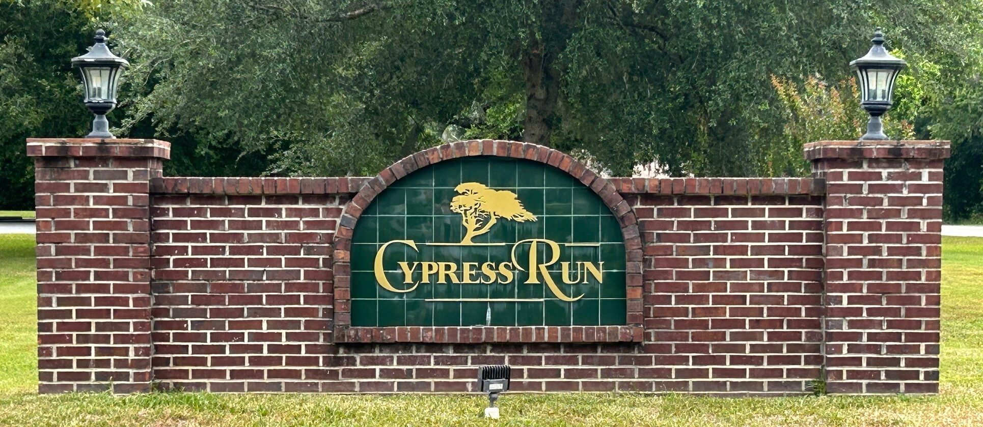 Cypress Run entrance sign with trees in the background.